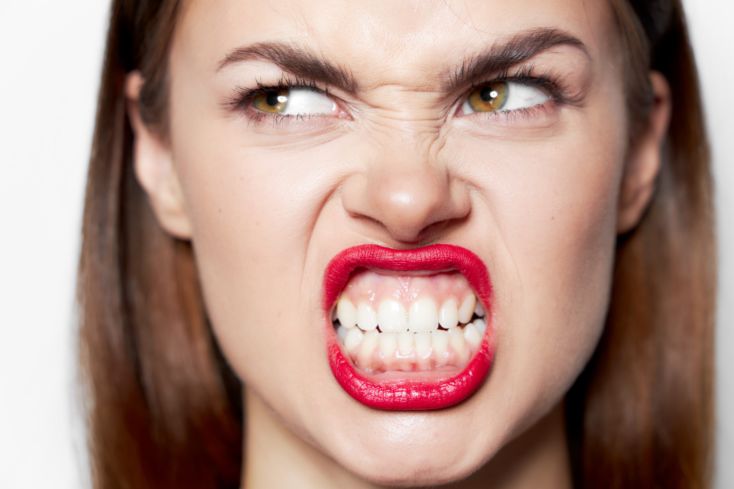 Portrait of a woman bares her teeth and looks aside a grimace of emotion